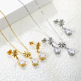 Flower + drop white diamond set Steel / Gold Earrings: 8.3mm flower + 6.2*10mm drop white diamond Pendant: 8.9mm flower + 6.2*10mm drop white diamond 0.3 Cross chain 42+5cm+6mm round plate