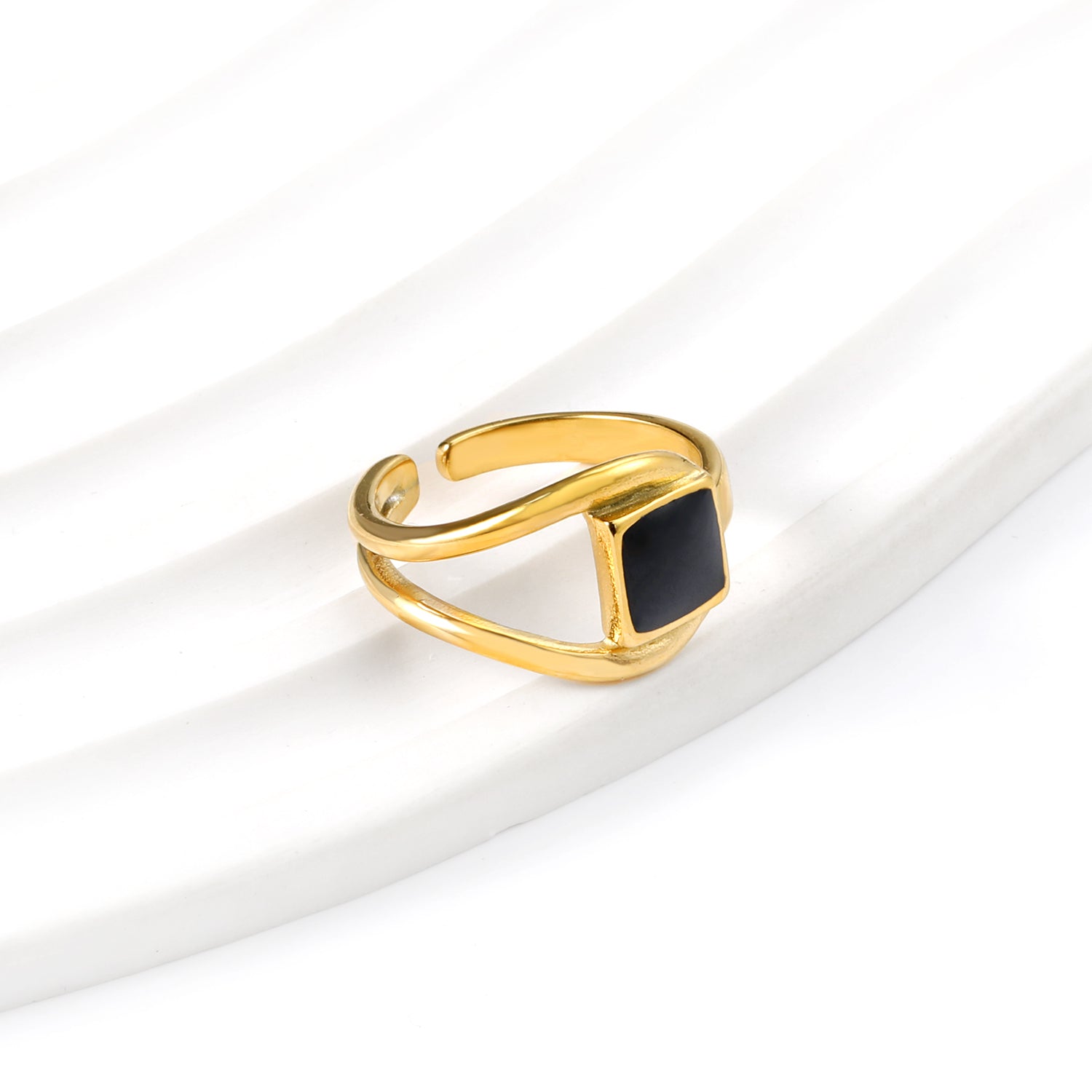 A minimalist ring with simple lines displayed with black drip polish asonjewelry