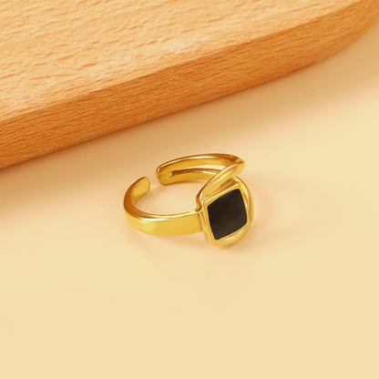 A minimalist ring with simple lines displayed with black drip polish asonjewelry
