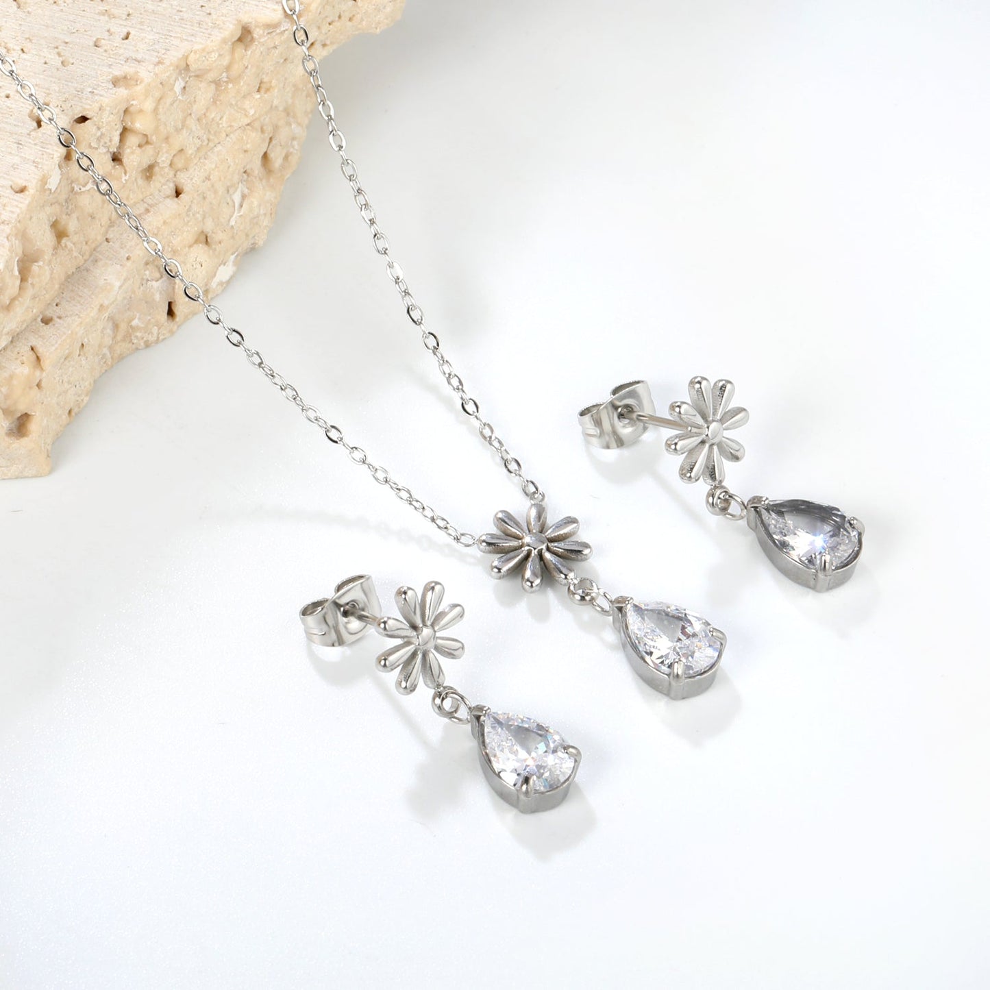 Flower + drop white diamond set Steel / Gold Earrings: 8.3mm flower + 6.2*10mm drop white diamond Pendant: 8.9mm flower + 6.2*10mm drop white diamond 0.3 Cross chain 42+5cm+6mm round plate asonjewelry