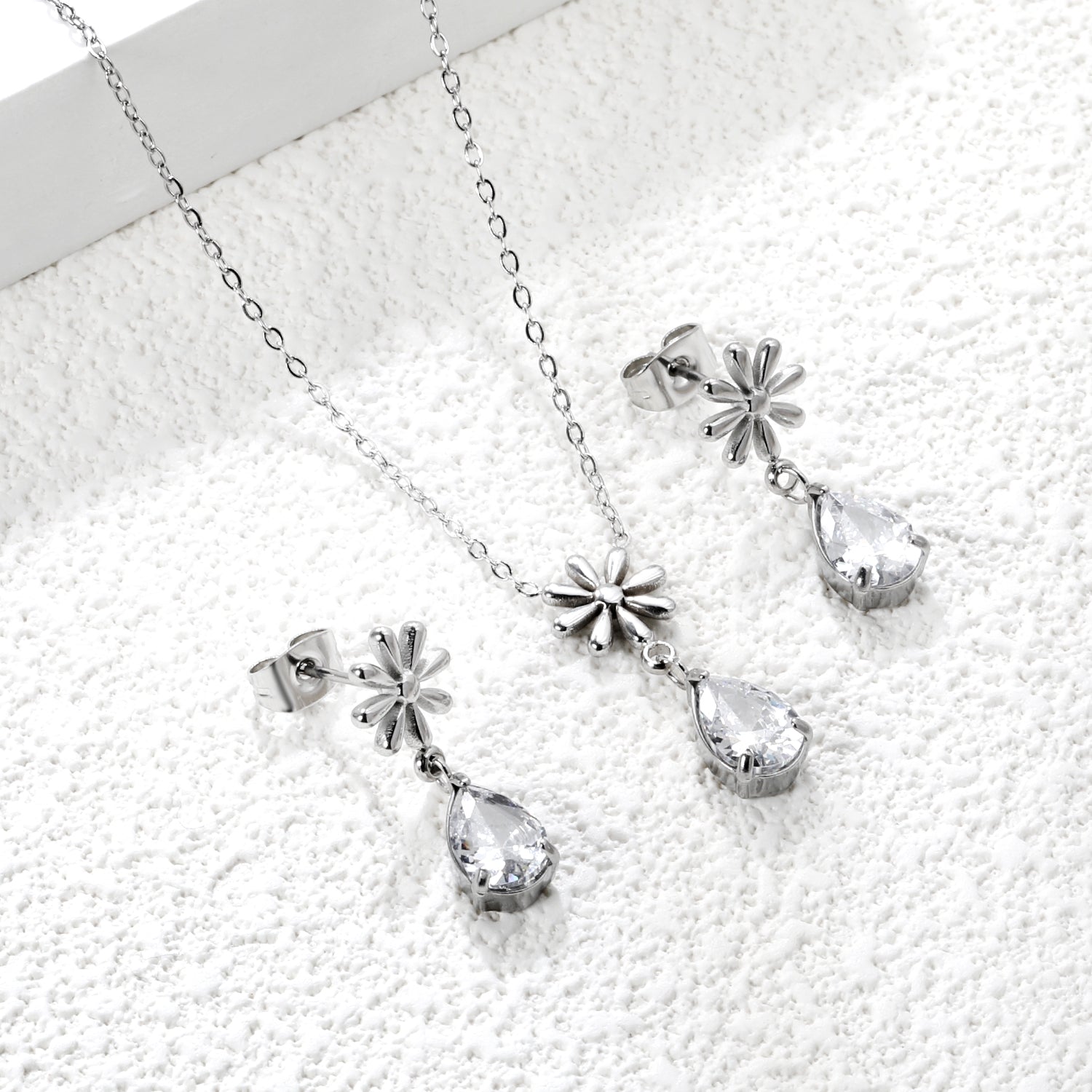 Flower + drop white diamond set Steel / Gold Earrings: 8.3mm flower + 6.2*10mm drop white diamond Pendant: 8.9mm flower + 6.2*10mm drop white diamond 0.3 Cross chain 42+5cm+6mm round plate asonjewelry