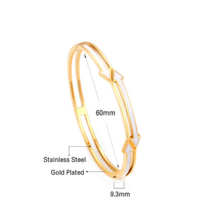 Gold colored hard bracelet with directional arrows with oil dripping in the center white color