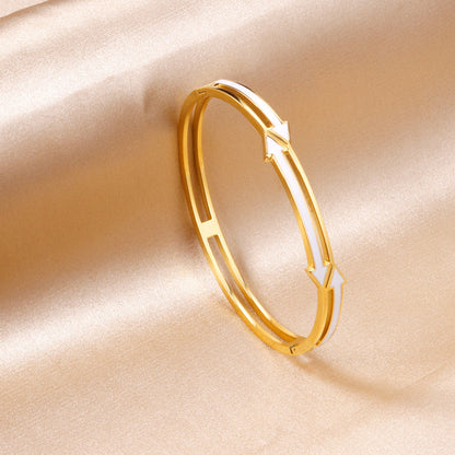 Gold colored hard bracelet with directional arrows with oil dripping in the center white color asonjewelry