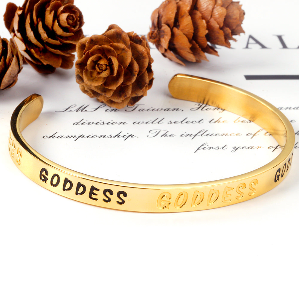 Gold colored hard bracelet with GODDESS printed on it asonjewelry