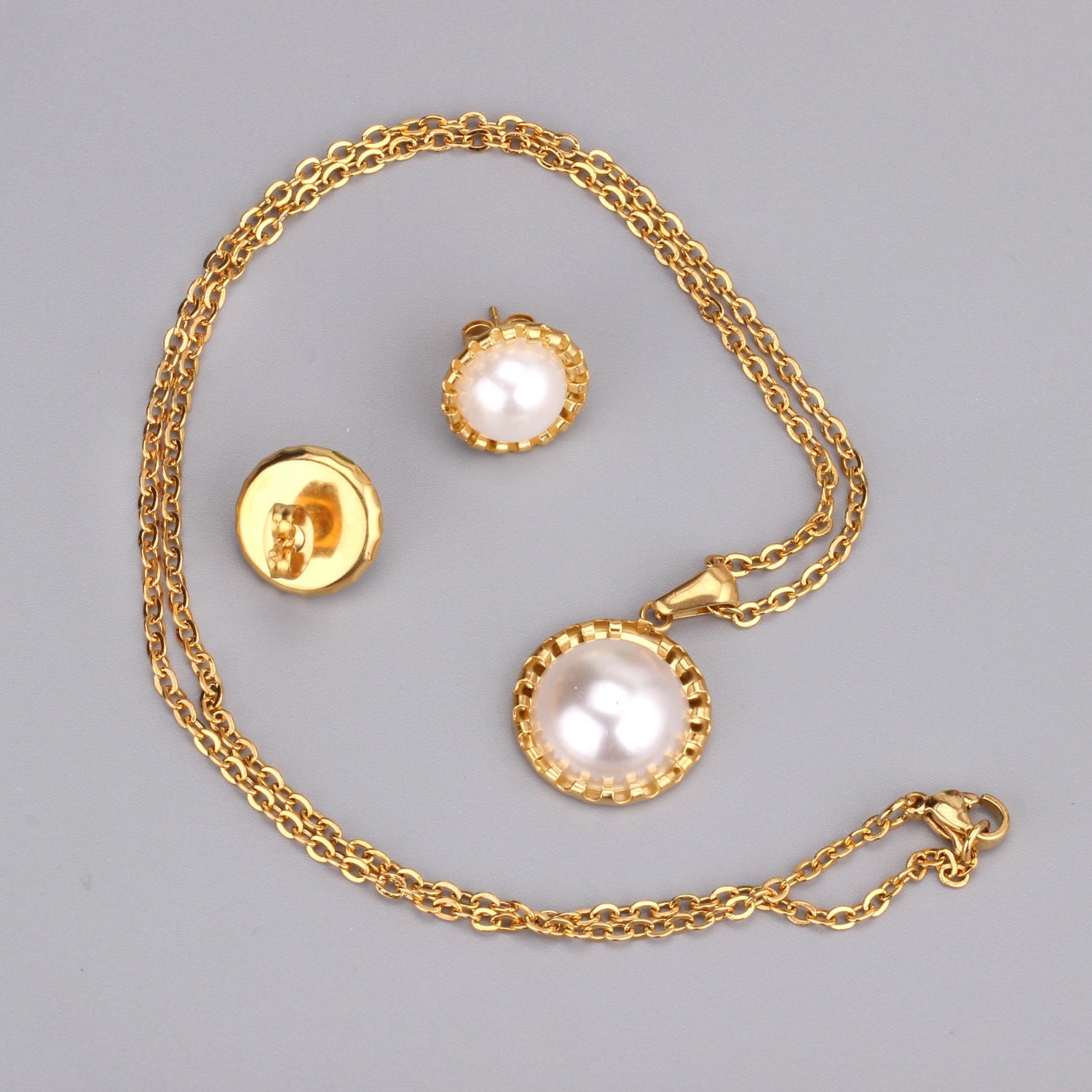 Gold/steel half pearl standing on top of round cake jewelry set asonjewelry